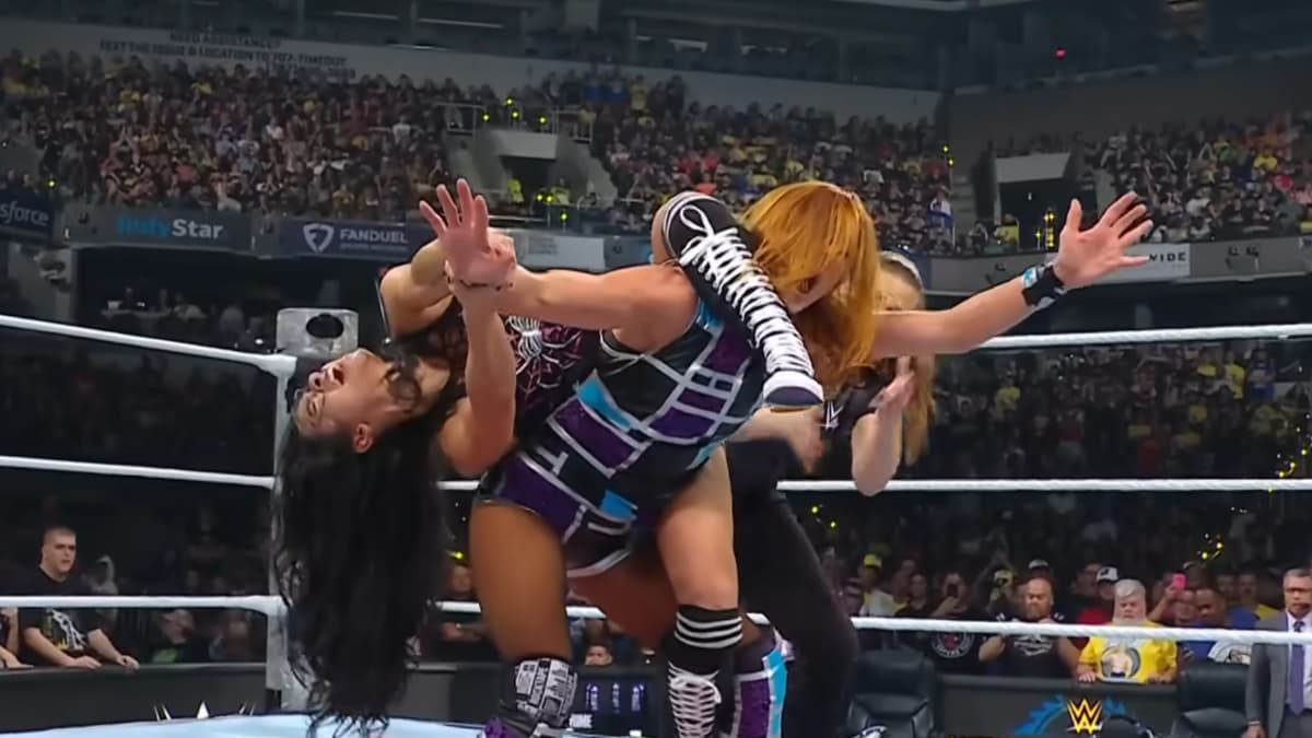 AJ Lee has Becky Lynch tied up in the Black Widow submission inside a WWE wrestling ring