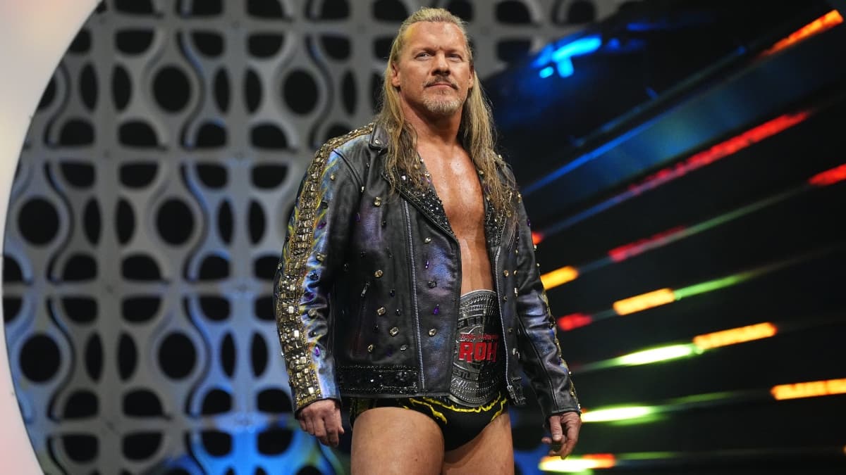 Chris Jericho in trunks wearing a leather jacket with the ROH World Title around his waist