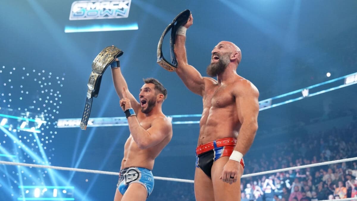 DIY holding up WWE Tag Team Titles in the ring 