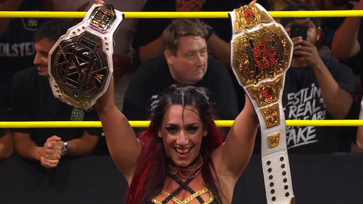 Jacy Jayne holding up the TNA and WWE NXT Women's titles