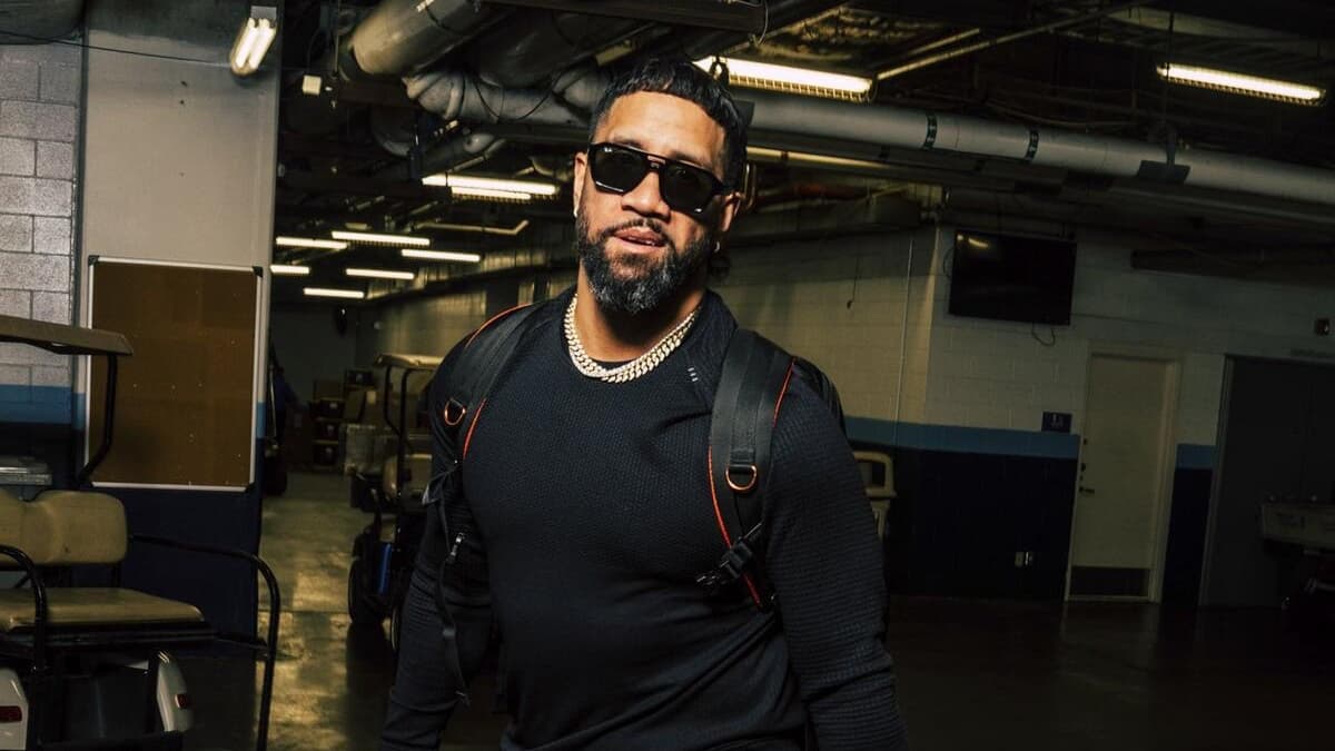 Jey Uso walking with a black jumper and sunglasses