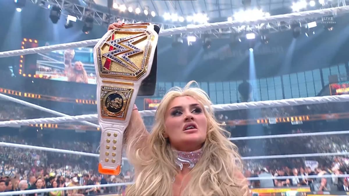Tiffany Stratton with a chipped tooth holding up the WWE Women's Title at WrestleMania 41