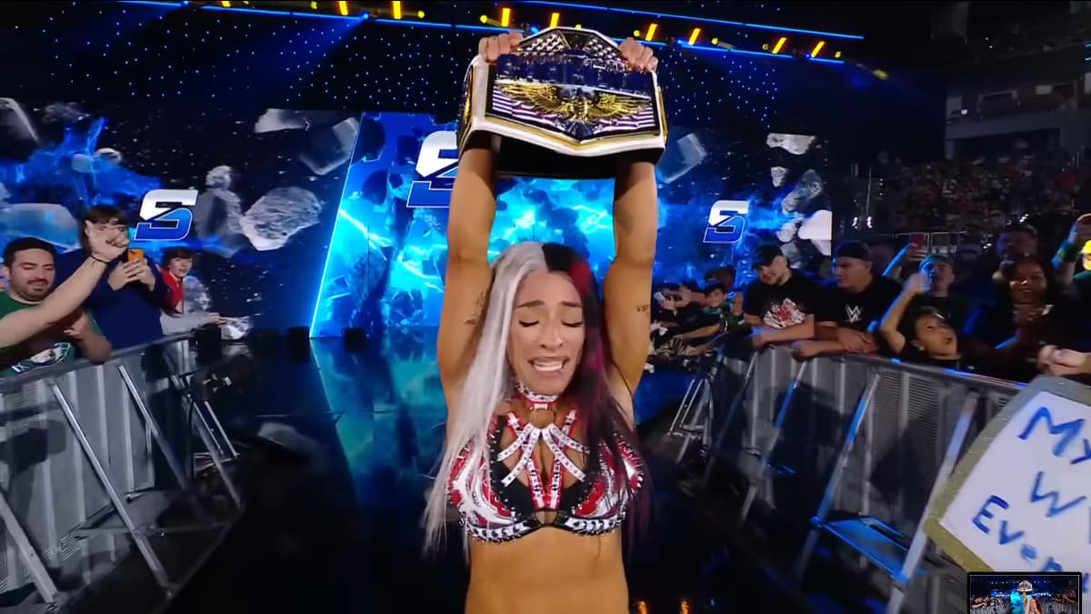 Zelina Vega lifting the WWE Women's United States Championship in front of the SmackDown entrance stage