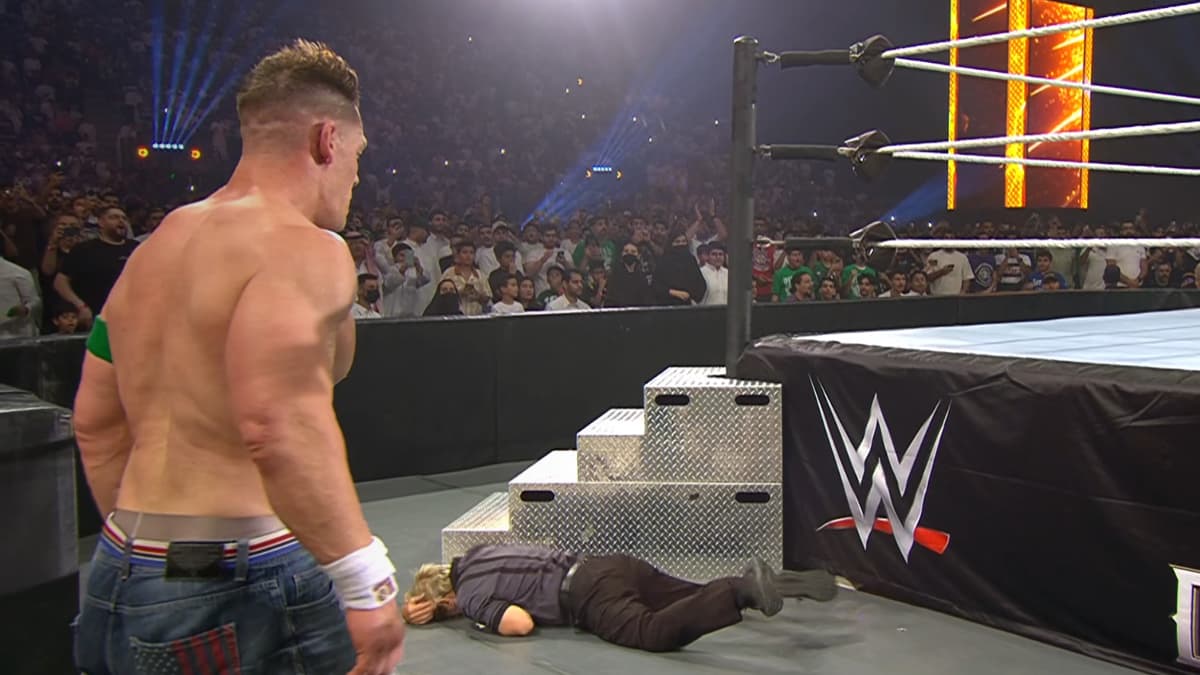 Charles Robinson rolling on the floor in pain as John Cena looks down at him from afar at WWE Night of Champions 2025