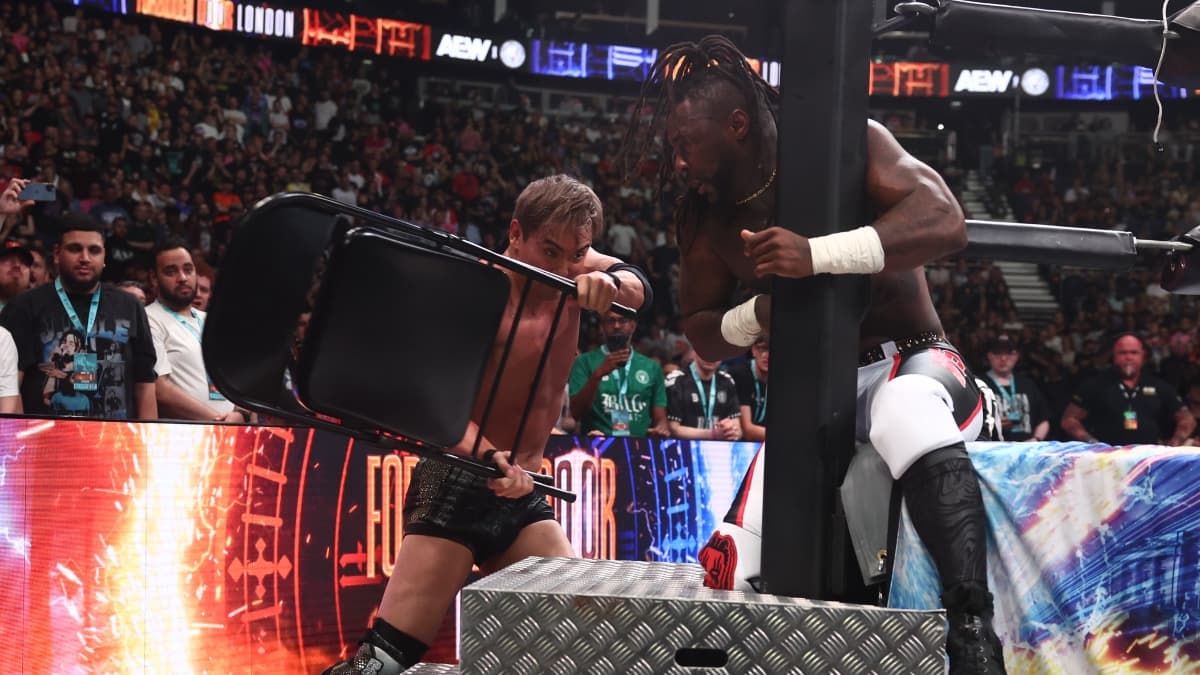 Kazuchika Okada hitting Swerve Strickland with a steel chair while Swerve is sitting next to the ring post